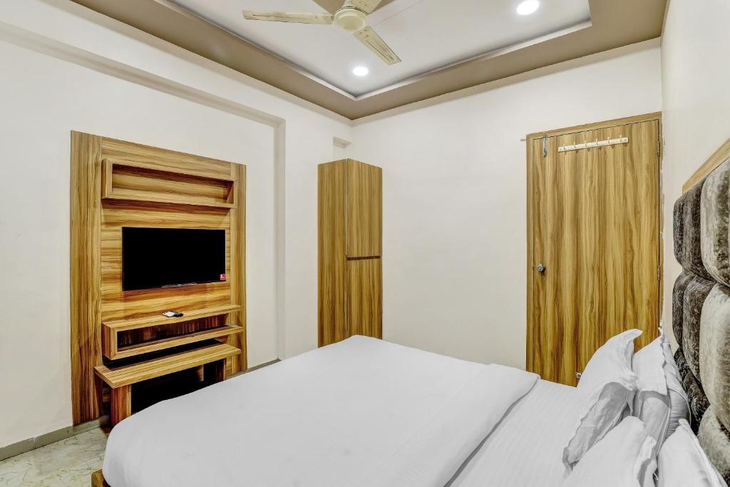 NarodaCapital O Hotel Maple View的一间卧室配有一张床和一台平面电视