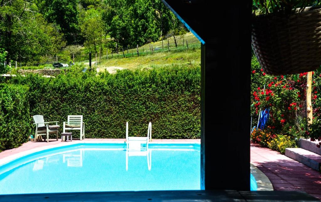 卡皮雷拉Los Castaños, Vivienda Rural, Capileira的一个带两把椅子和一张桌子的游泳池