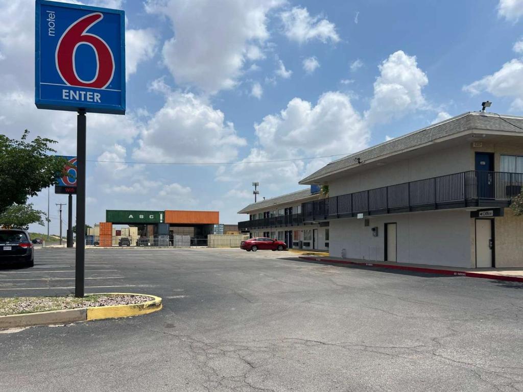 奥德萨Motel 6-Odessa, TX的建筑物前停车场的标志