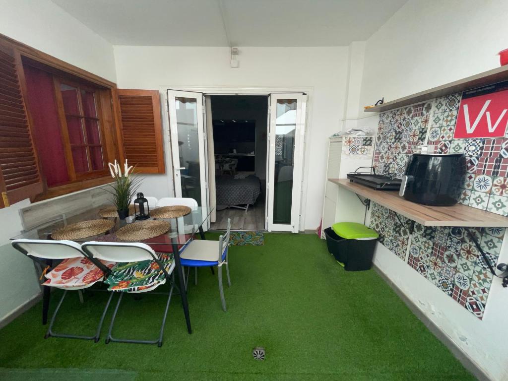 洛斯克里斯蒂亚诺斯Apartamento Sofia Los Cristianos的绿色地毯和桌椅的房间