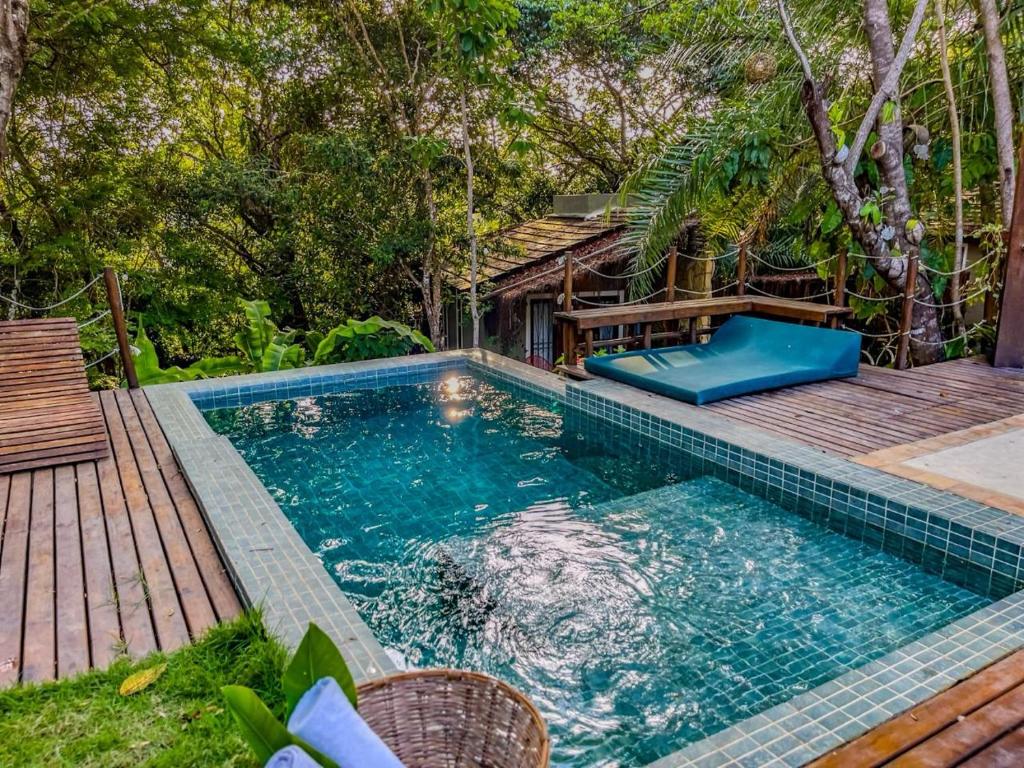 圣米格尔-杜斯米拉格里斯SITIO VILLA DA MATA的一座带木甲板的游泳池,位于一座房子旁边