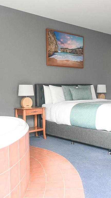 坎贝尔港波浪豪华套房酒店的一间卧室设有两张床,墙上挂着一幅画