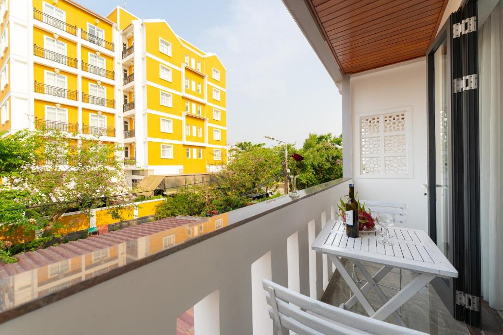 会安May Boutique Villa Hội An的阳台配有桌子,享有建筑的景致。