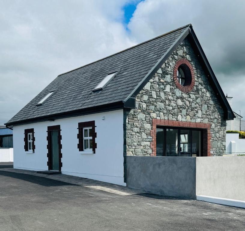 BrackhillDe Búrca Cottage KERRY的一座白色的小建筑,有黑色的屋顶
