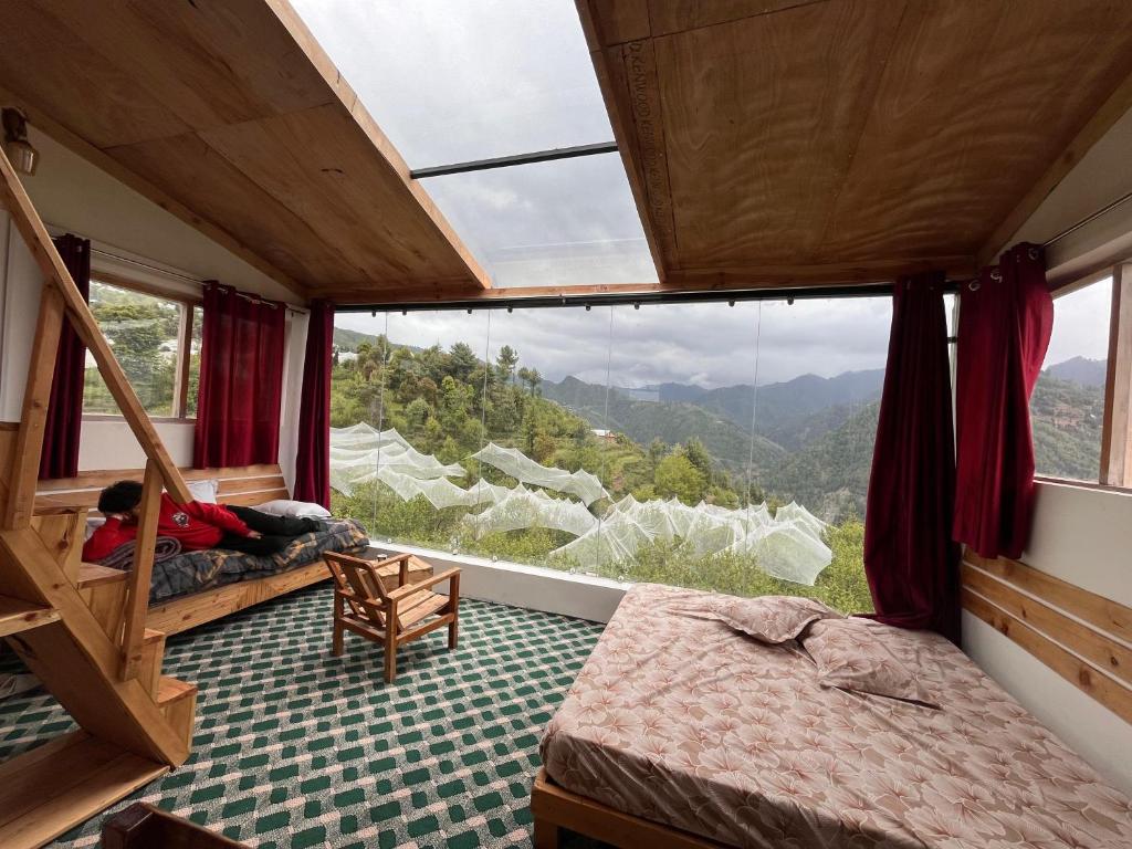 马恩迪Stargazing Glass Lodge Himachal Pradesh Thachi的一间带大窗户的卧室