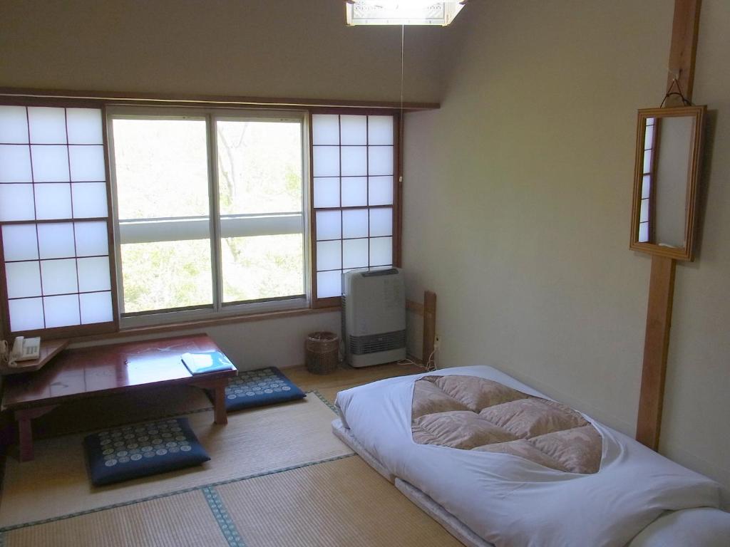 箱根富士箱根旅馆的卧室配有一张床、一张书桌和窗户。