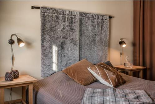 萨伦Skistar Lodge Lindvallen的一间卧室配有一张带两张桌子和一扇窗户的床。