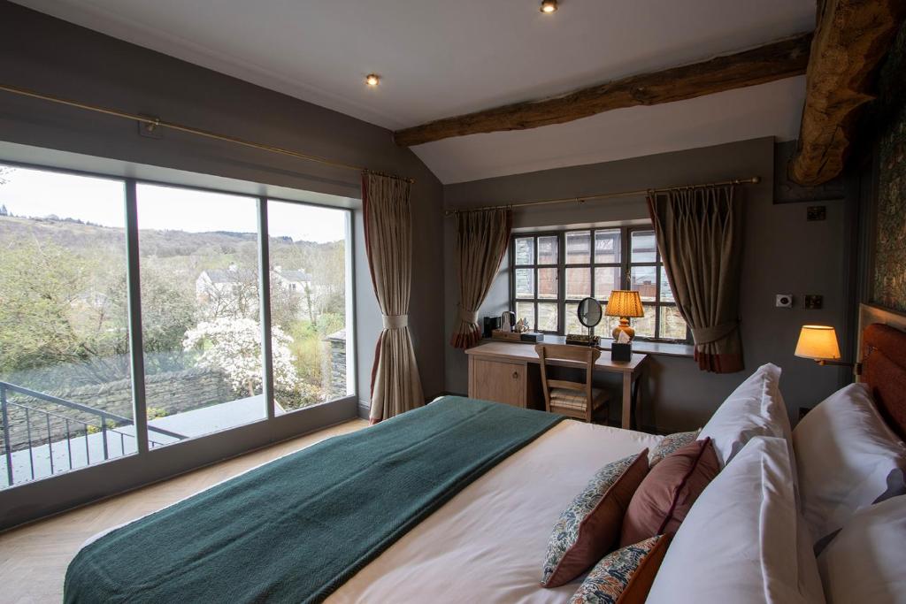 霍克斯黑德女王头旅店及餐馆的一间卧室配有一张床、一张书桌和一个窗户。