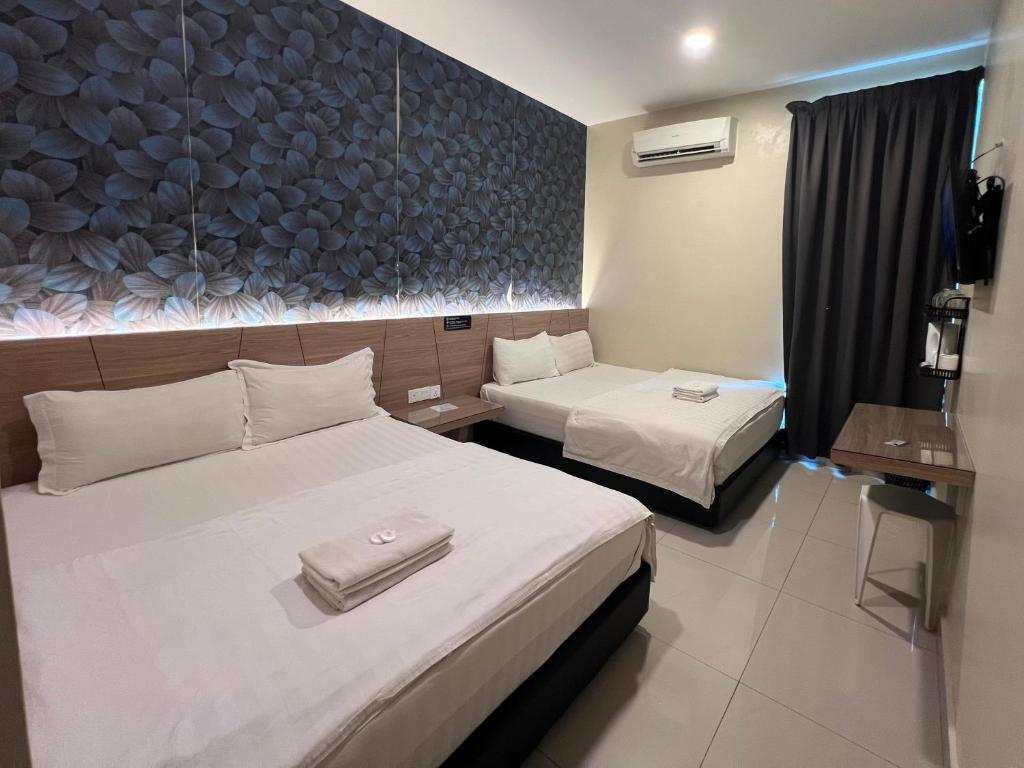 关丹格邦工业园经济型酒店的酒店客房带两张床和一面墙