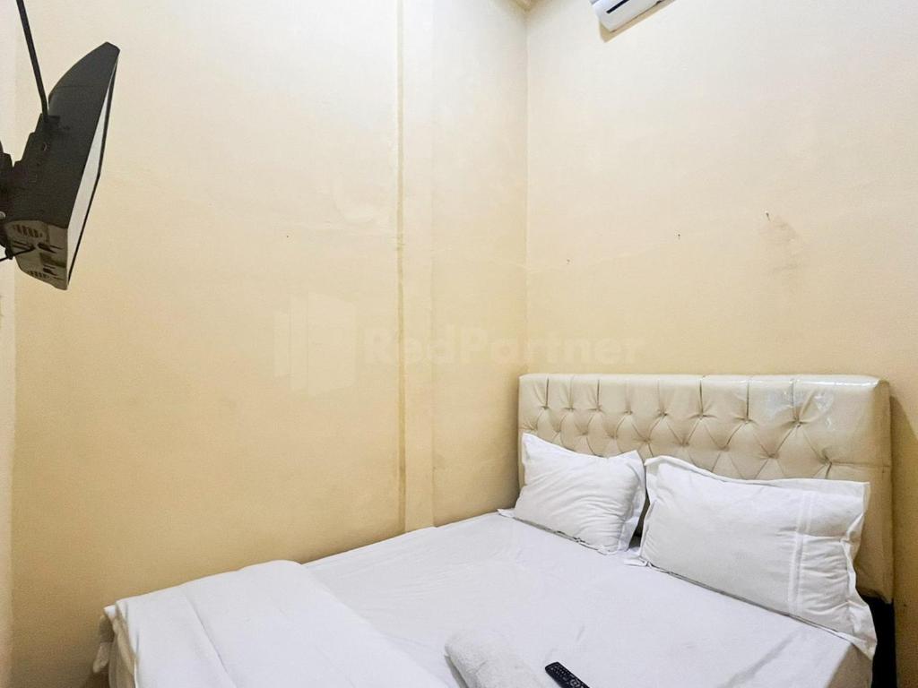 巨港Penginapan Dvn & Tmy 01 RedPartner的一间卧室配有带白色床单和枕头的床。