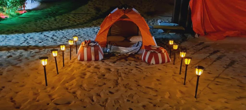 HunaywahRoyal Desert Tourism LLC的一组在沙子里的蜡烛和帐篷