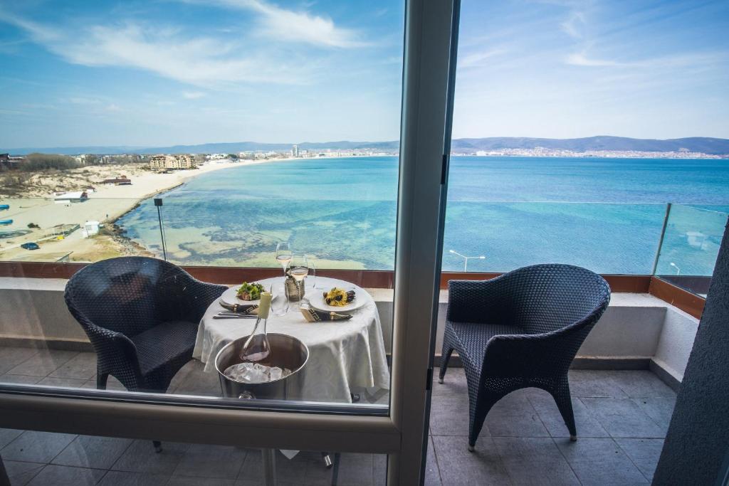 内塞伯尔Paradiso Dreams Hotel的一张桌子和两把椅子,享有海滩美景