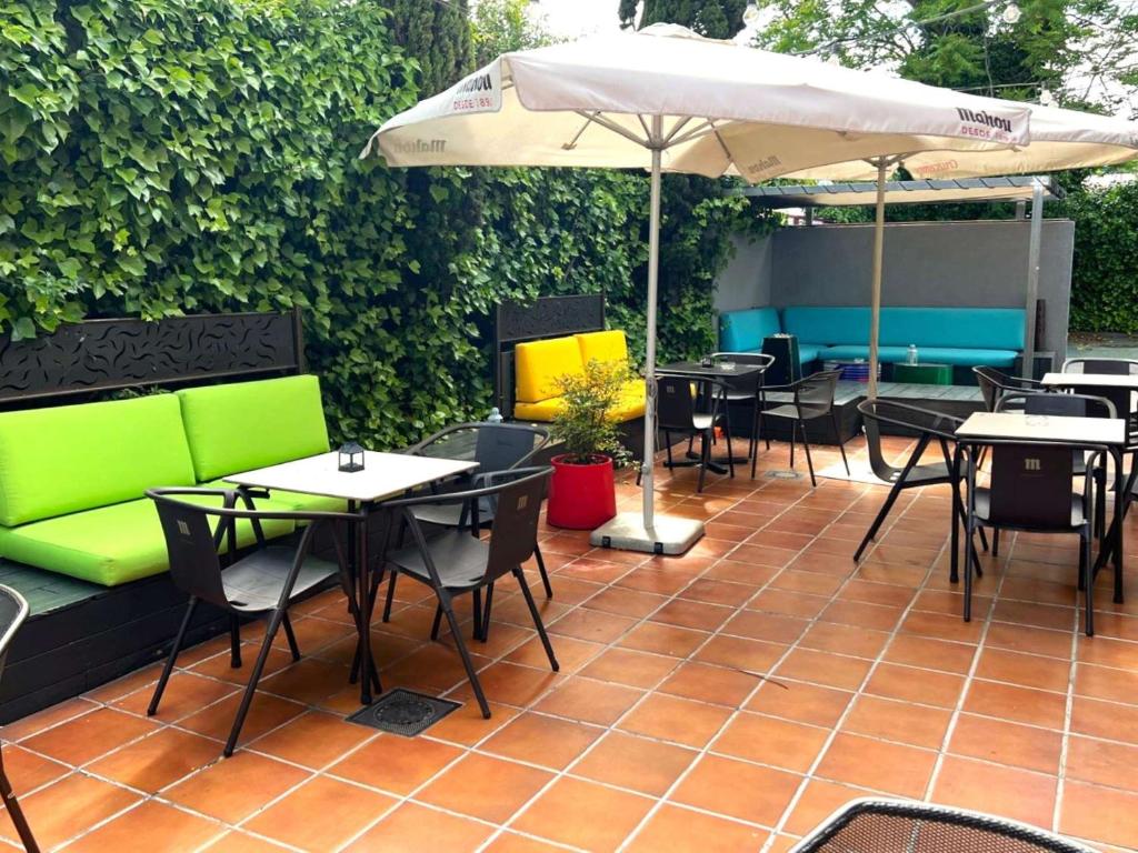 富恩拉夫拉达宜必思马德里丰拉夫拉达酒店的一个带桌椅和遮阳伞的庭院