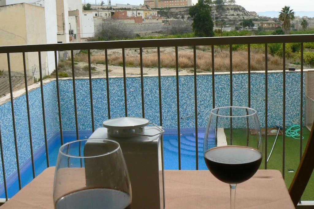 穆尔西亚Apartamento en centro de Archena的阳台上的桌子和两杯葡萄酒