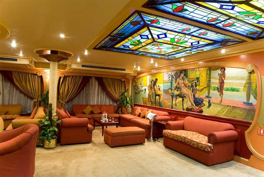 Nag` el-FuqâhiM/s Nile crown II的一间配有沙发和彩色玻璃天花板的客房