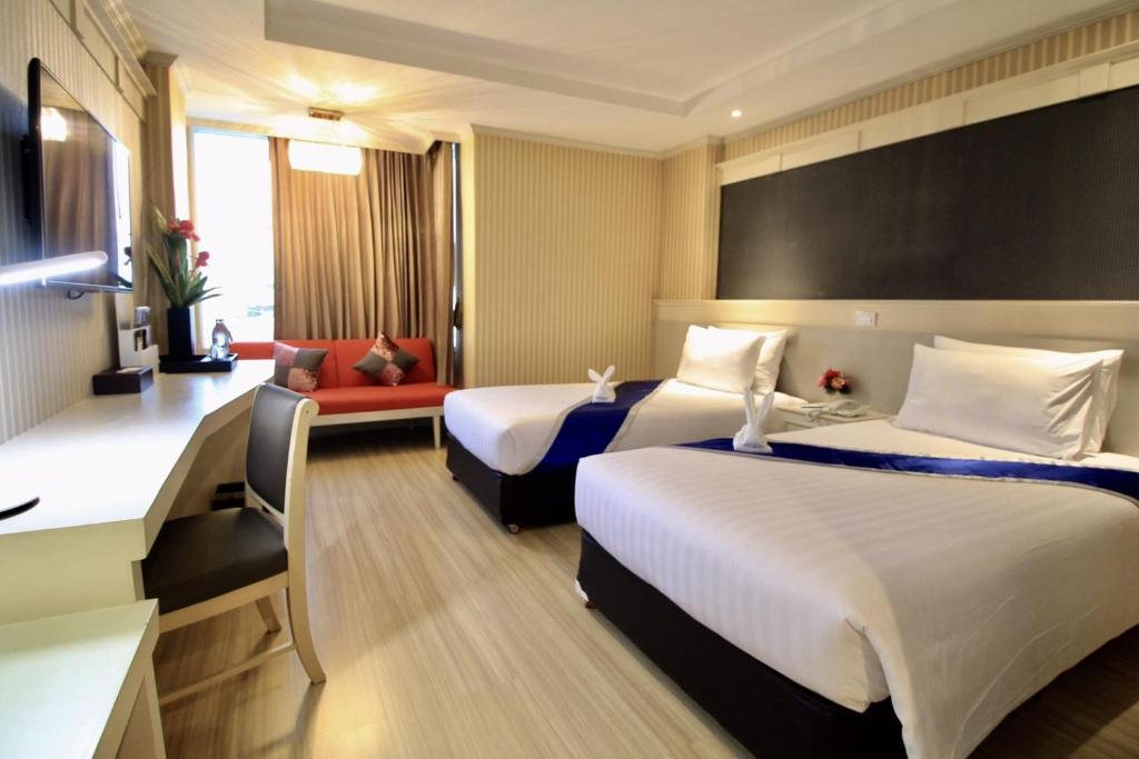 坤敬โรงแรมวีวิช V Wish Hotel的酒店客房带两张床和一张红色沙发