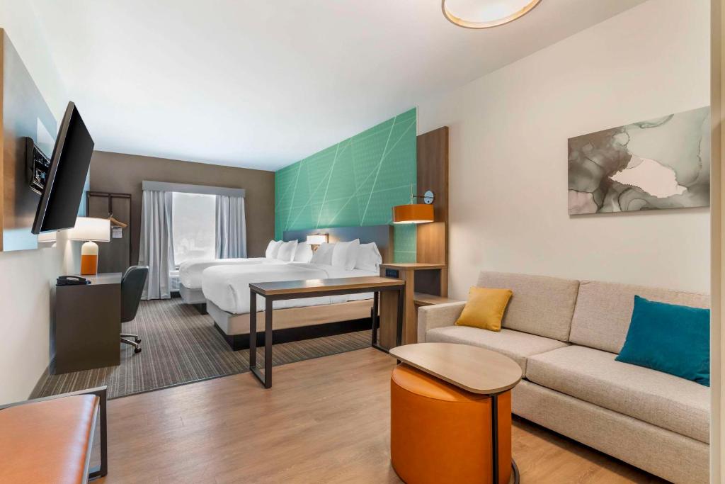 加特林堡Comfort Suites Gatlinburg Downtown-Convention Center的酒店客房,配有床和沙发