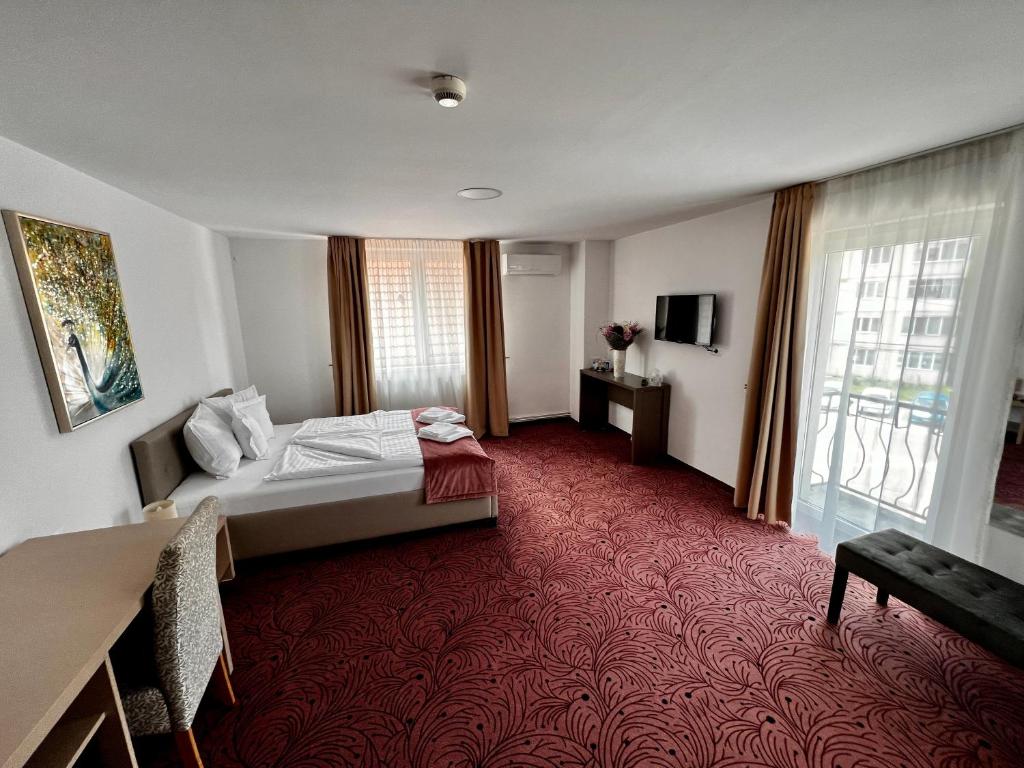 锡比乌Pensiunea Simar的酒店客房,配有床铺和红地毯