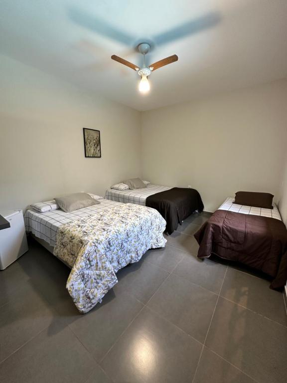 德尔菲诺波利斯casa inteira com 3 suites e área de lazer的一间卧室配有两张床和吊扇