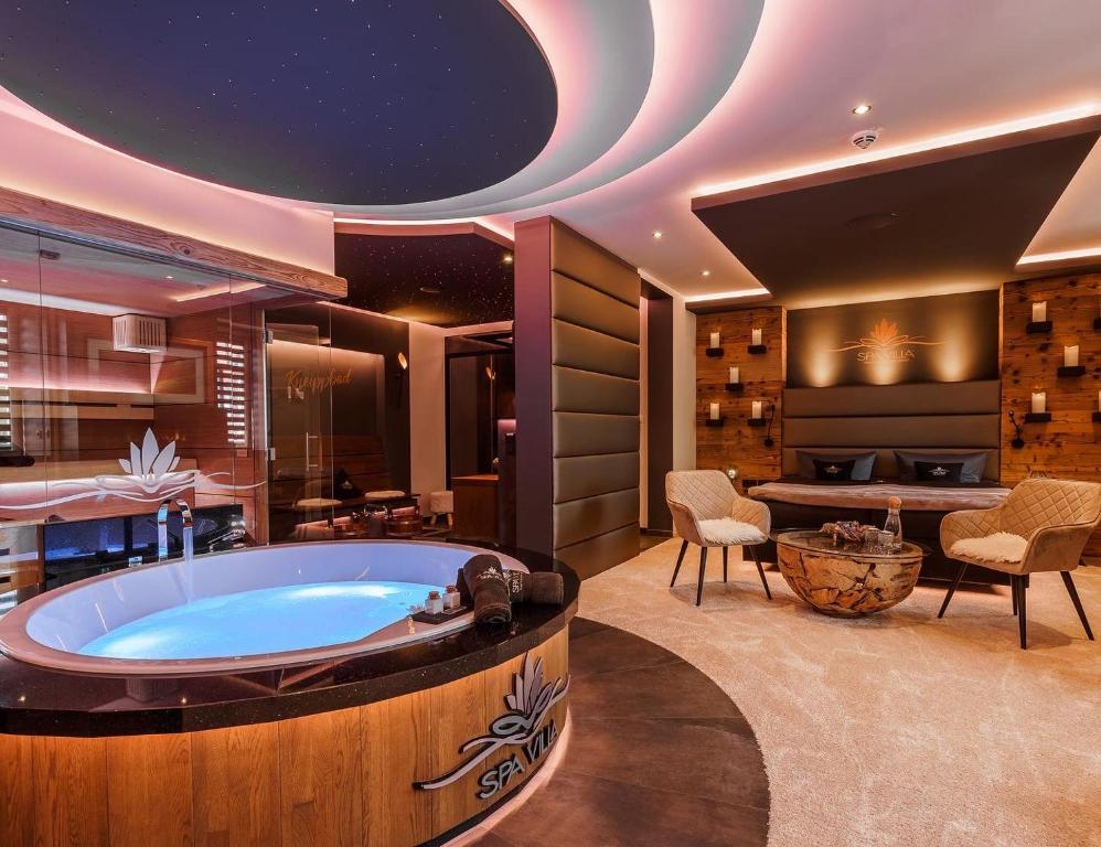WingerodeSpa Villa Beauty & Wellness Resort的一个带桌椅的客房内按摩浴缸