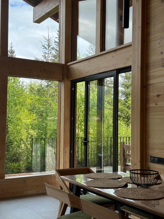 沃罗赫塔MOKHY Chalet & Nature的一间设有大窗户和桌子的用餐室