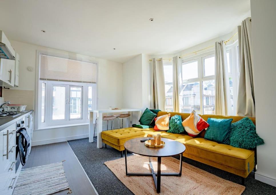 伦敦Guest Homes - Lewisham Flat的客厅配有黄色的沙发和桌子