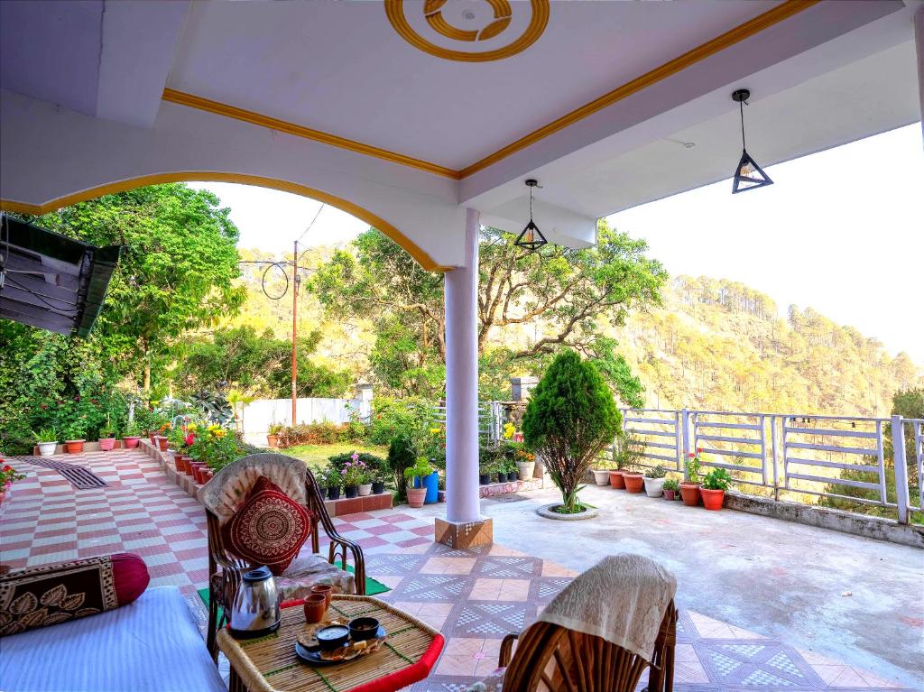 奈尼塔尔Nature's Vibe Homestay - Nainital - Kainchi Dham的天井上配有桌椅的门廊