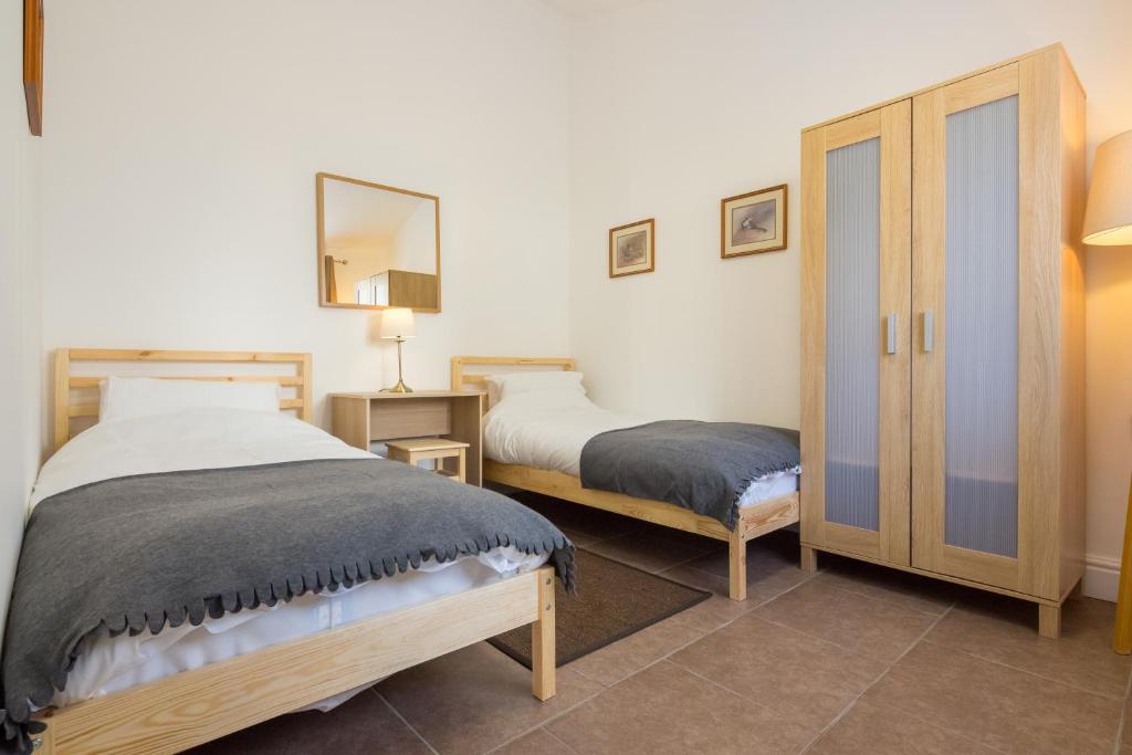 剑桥剑桥水屋公寓的一间卧室配有两张床和镜子