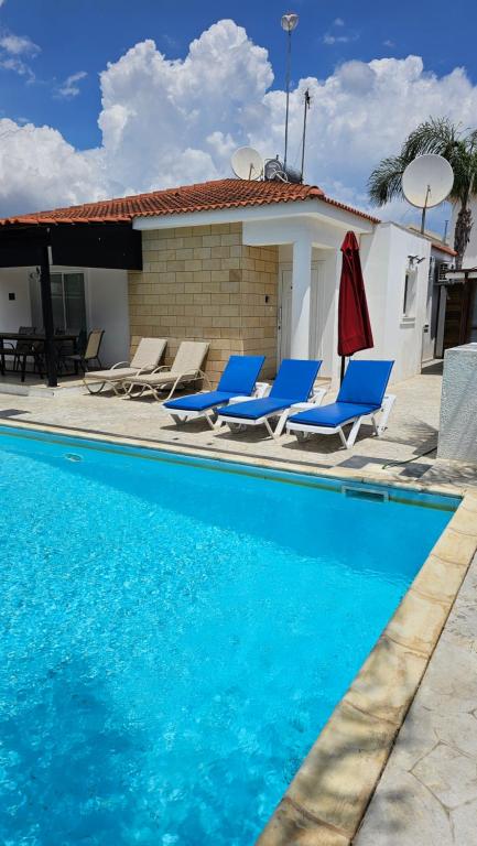 阿依纳帕格拉西亚别墅的一个带蓝色椅子的游泳池