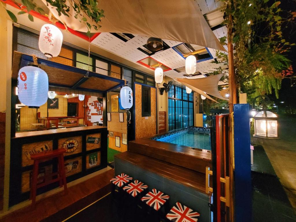Ban Chak Khaminอีโฮสเทลบ้านช่น的一间酒吧,在餐厅里设有游泳池