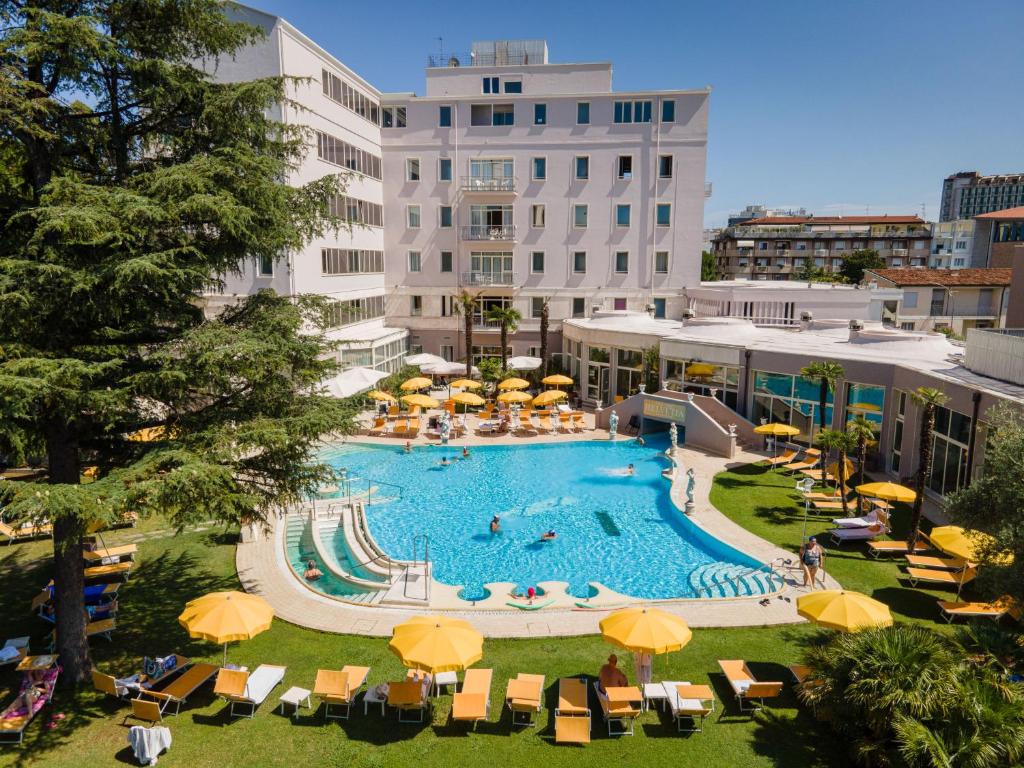 阿巴诺泰尔梅海尔维温泉酒店的一个带黄色遮阳伞和椅子的大型游泳池