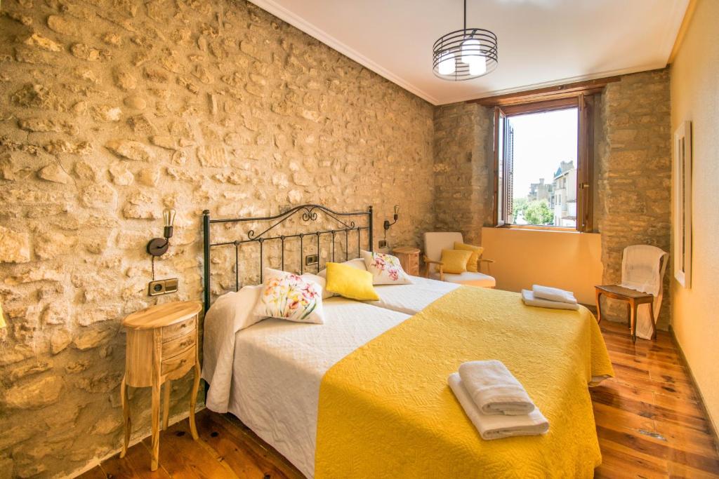 奥利特Ronda del Castillo的卧室配有一张石墙内的大床