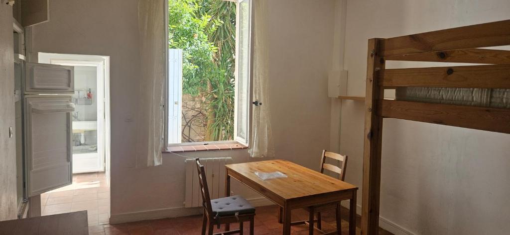 Portel-des-CorbièresStudio entre mer et garrigues的窗户客房内的桌椅