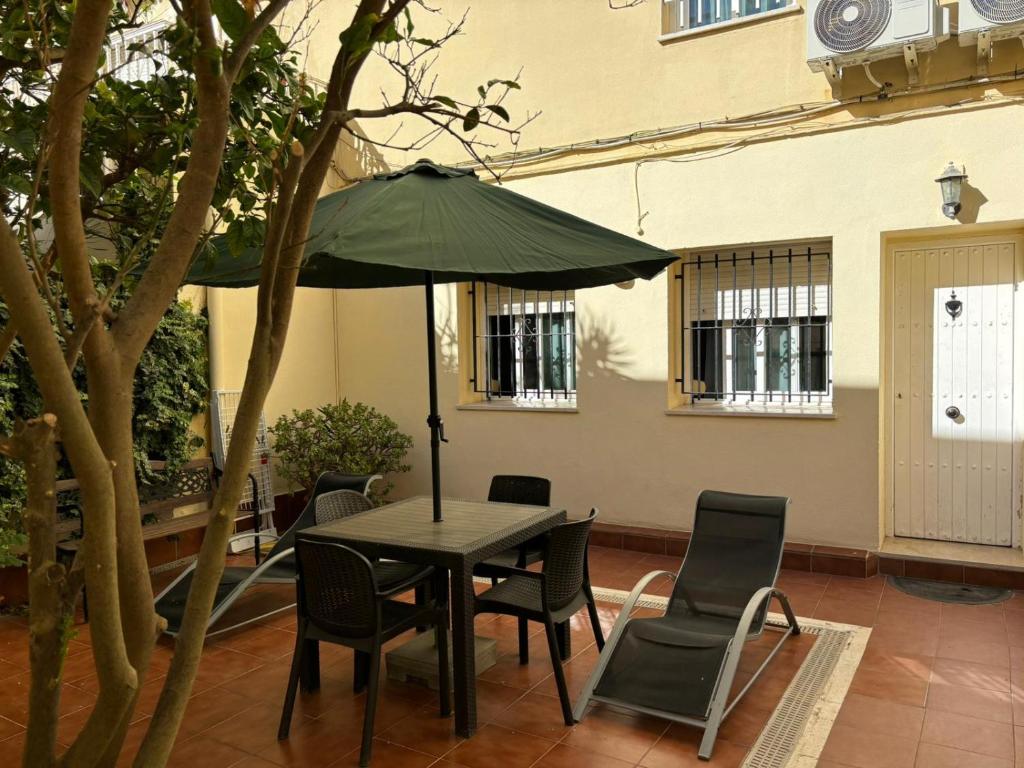 加的斯伊马尔旅馆的庭院里配有桌椅和遮阳伞