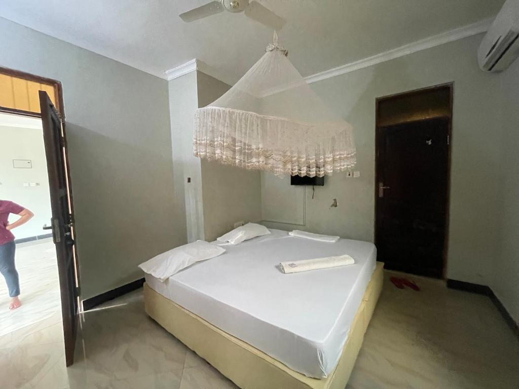 达累斯萨拉姆Konokono Mbezi beach的卧室配有白色床和吊灯