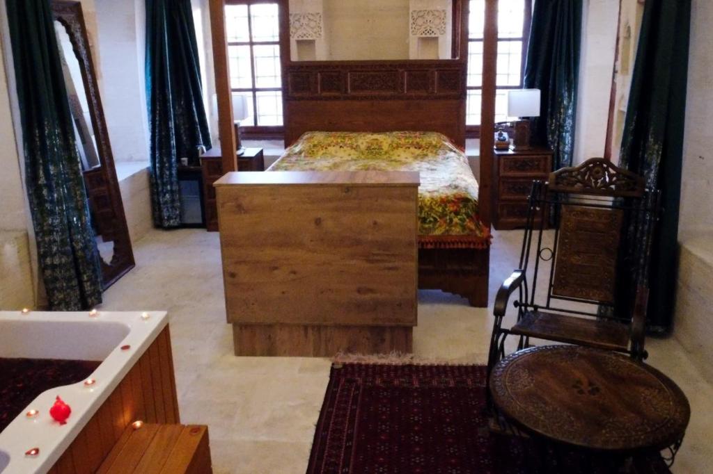 MidyatHercai Butik Otel的一间卧室配有一张带梳妆台和书桌的床。