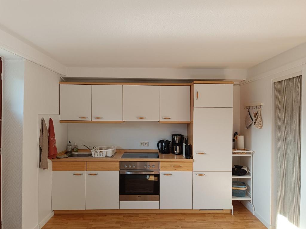 SüselAppartement Plögemaker的厨房配有白色橱柜和炉灶。