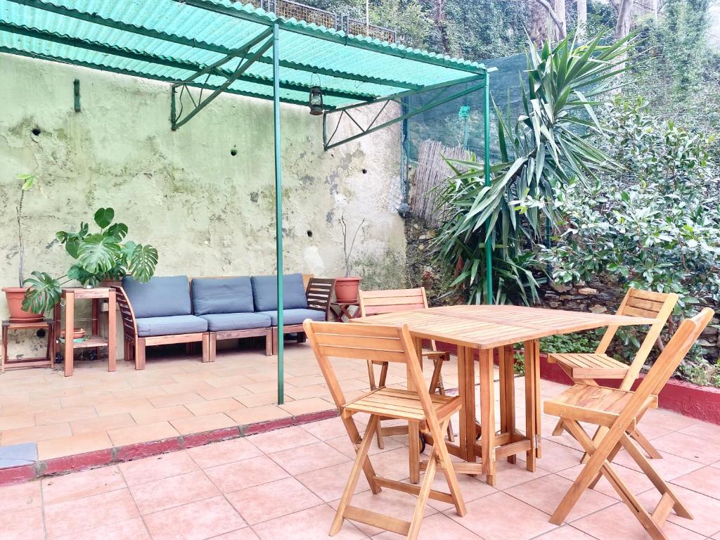 热那亚CasaViva - Bilo with patio in Genova San Teodoro的绿色伞下的木桌和椅子