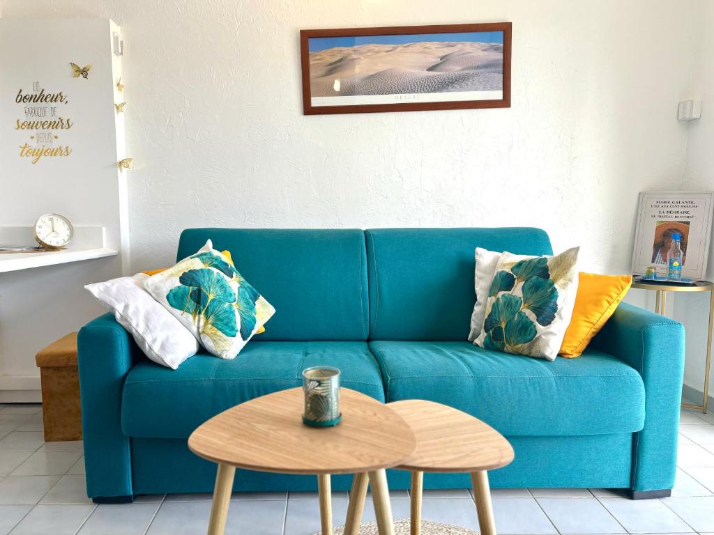 大博格La Kawanaise Blue Lagon的客厅配有一张蓝色的沙发,配有一张桌子