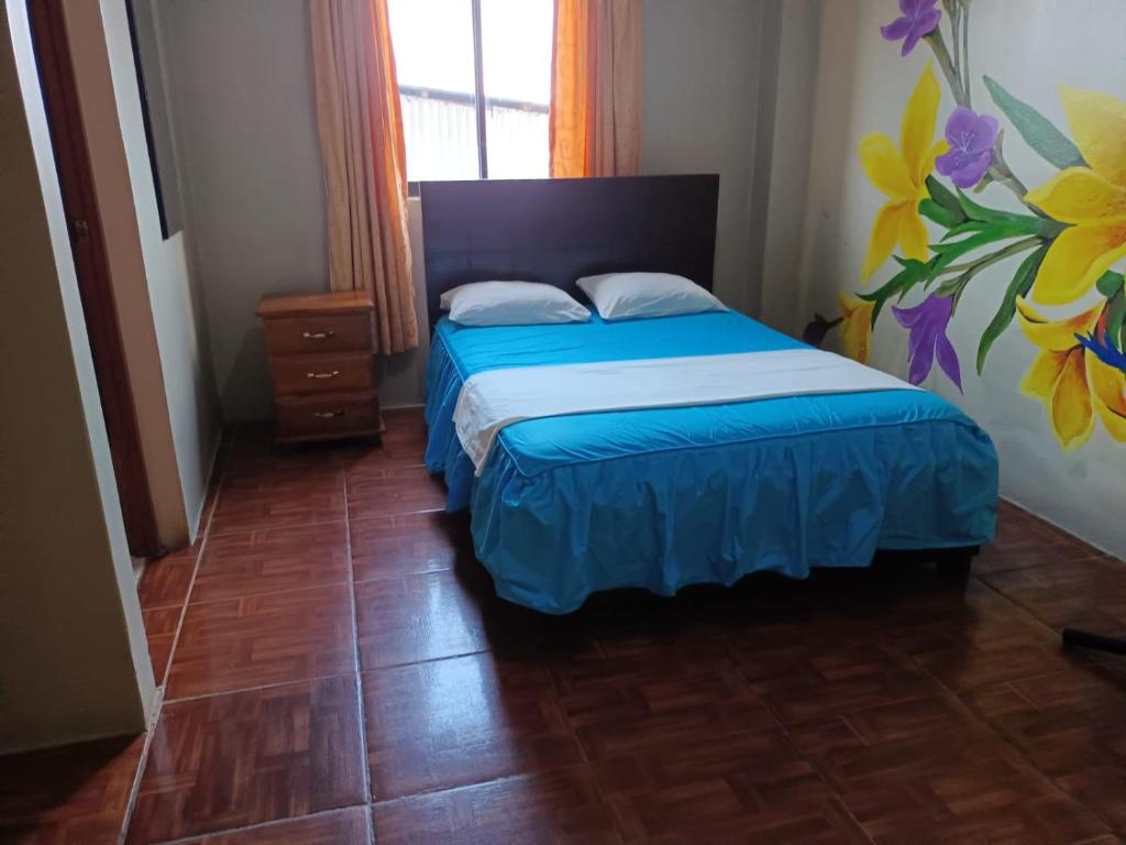 普卡尔帕埃尔啡旅馆的一间卧室配有一张带蓝色床罩的床