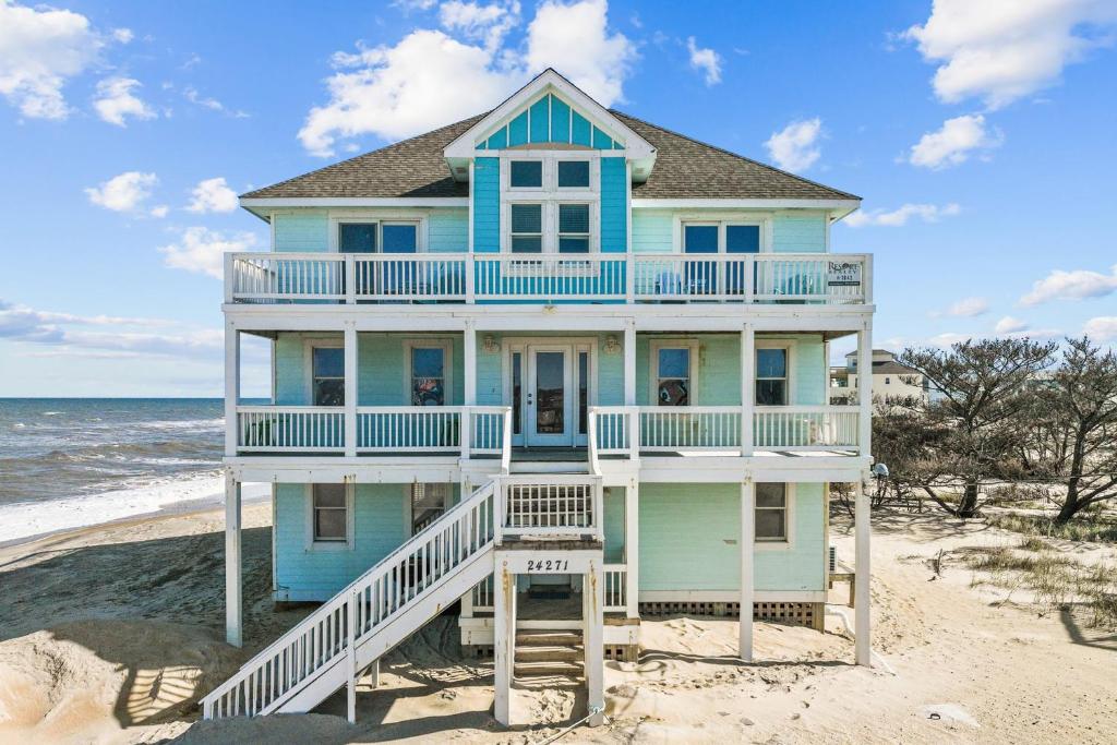 罗丹特7042 - Whistling Oyster by Resort Realty的海滩上的蓝色房子与大海
