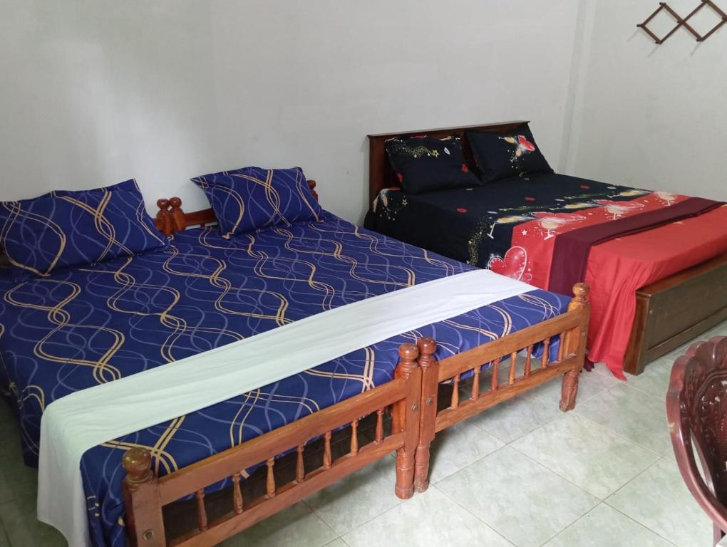 贾夫纳Mylooran Hotel的一间带两张床和一张沙发的卧室