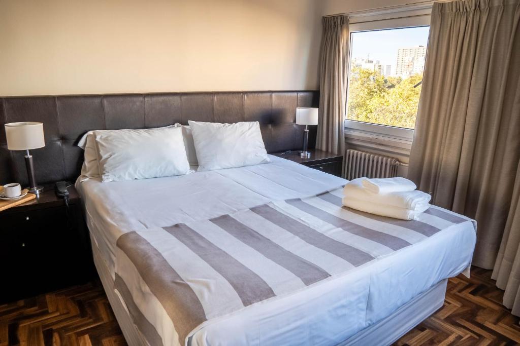 马德普拉塔泛美大酒店的一间卧室设有一张大床和窗户