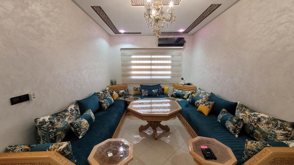 梅克内斯Bel appartement dans une résidence calme的客厅配有蓝色的沙发和桌子