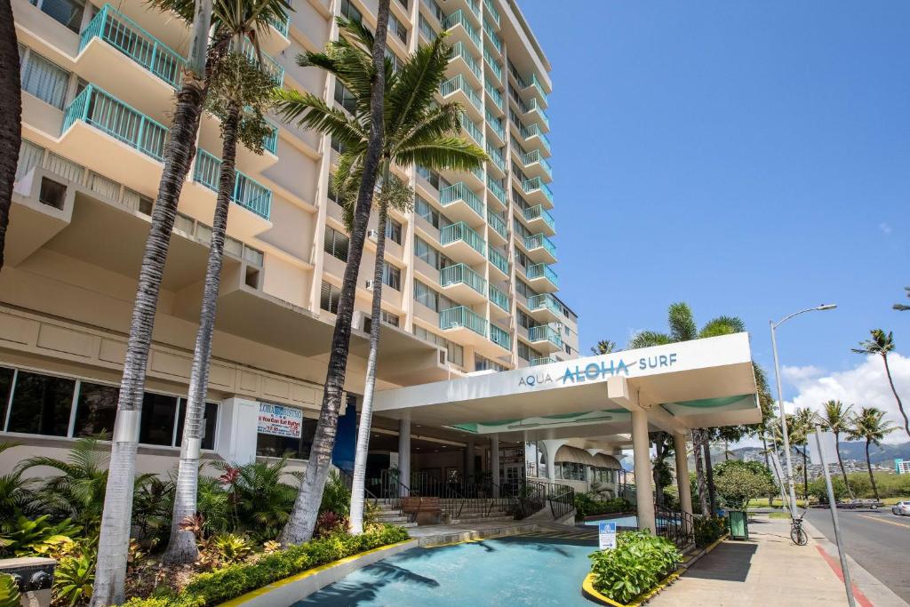 檀香山威基基阿瓜阿洛哈冲浪酒店的大楼前设有游泳池的酒店