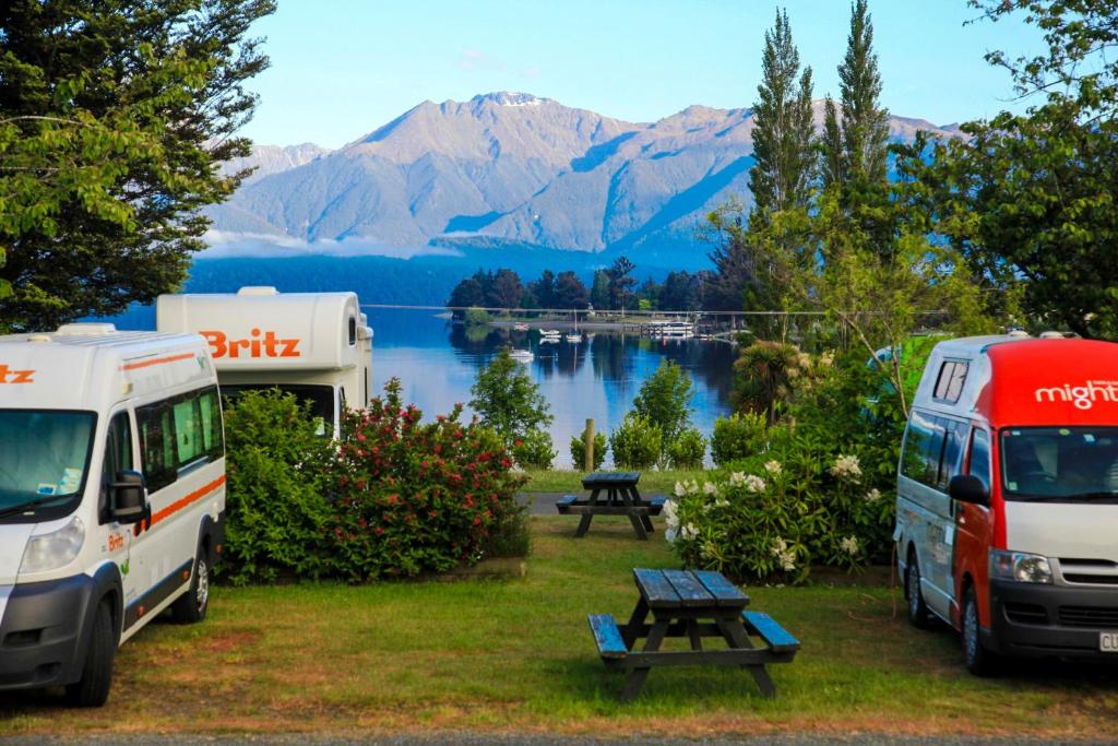 蒂阿瑙Te Anau Lakeview Holiday Park & Motels的两辆汽车停放在营地,享有湖景