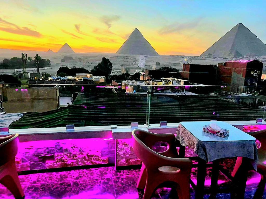 开罗MagiC Pyramids INN的一间设有桌子并享有金字塔景色的餐厅