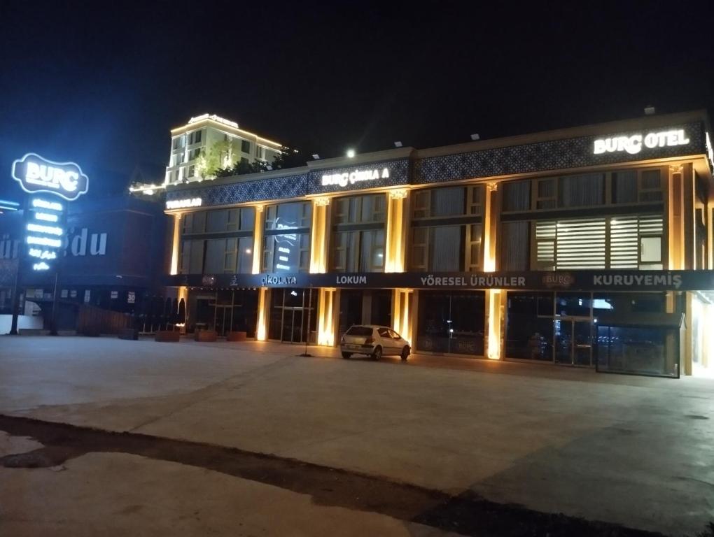 PelitliBurç Otel的夜间停在大楼前的汽车