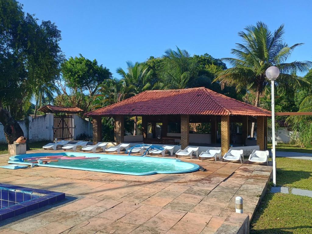 伊塔帕里卡Pousada Villa do Mar的一个带躺椅和凉亭的游泳池