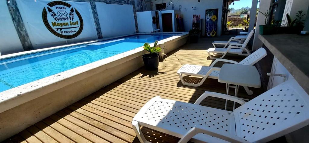 El Paredón Buena VistaMAYAN SURF HOTEL的一个带椅子的甲板和一个游泳池